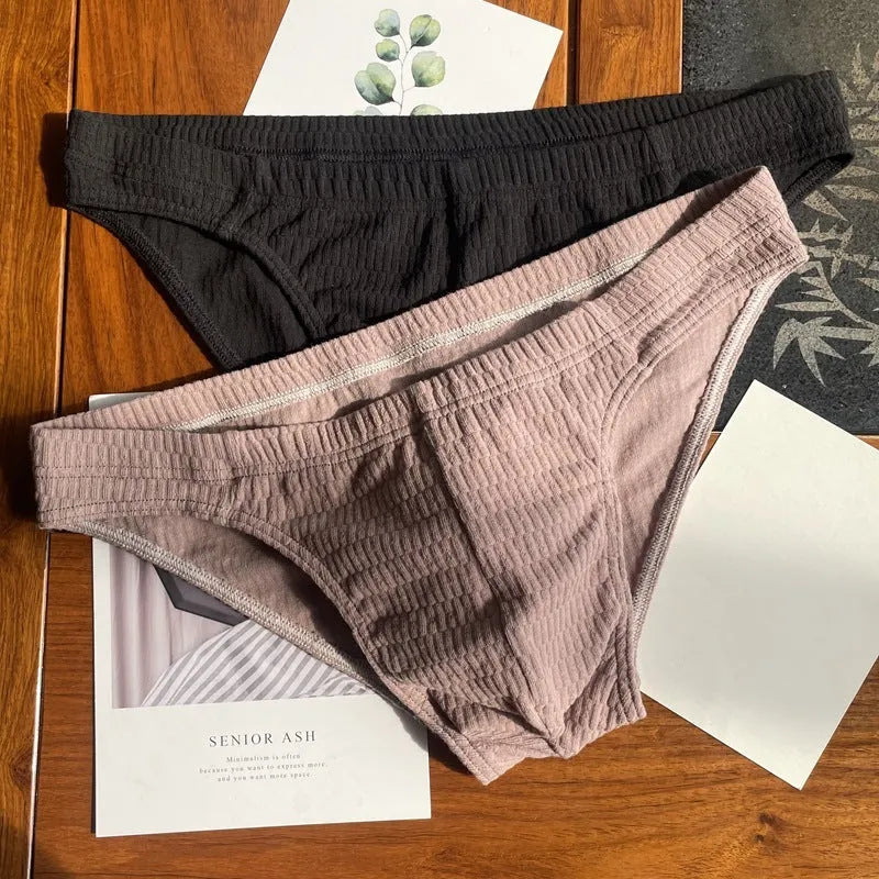 Men's solid colour cotton briefs with mid waist and triangle style in apricot black and skin colour.