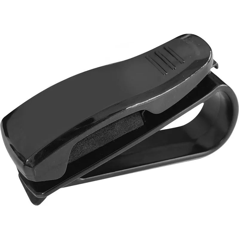 Black plastic clip for car sun visor holding a pair of glasses and a ticket.