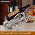 Lobster-shaped wine rack theme ornament in rose gold or silver resin and plastic finish on a shelf.