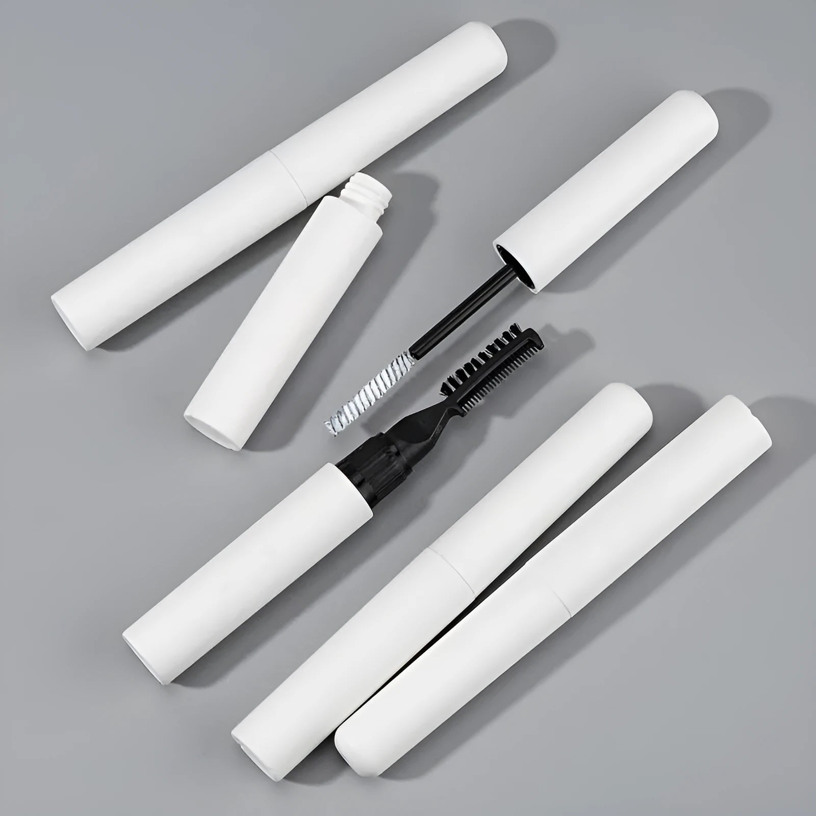 Eyebrow glue cosmetic adhesive in white and pink colour options with applicator