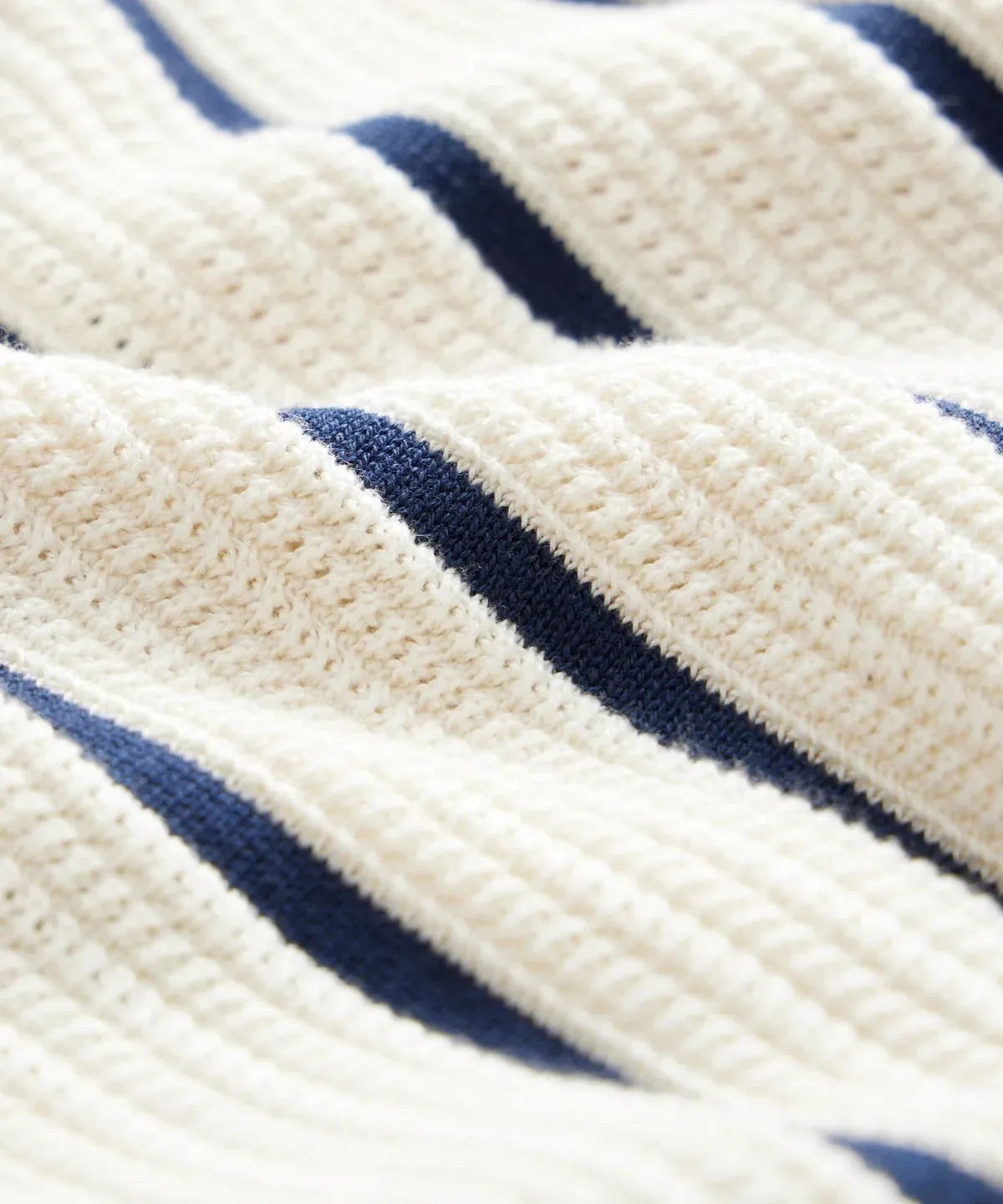 Men's white short sleeve knitted shirt with an asymmetric lapel, laid flat.