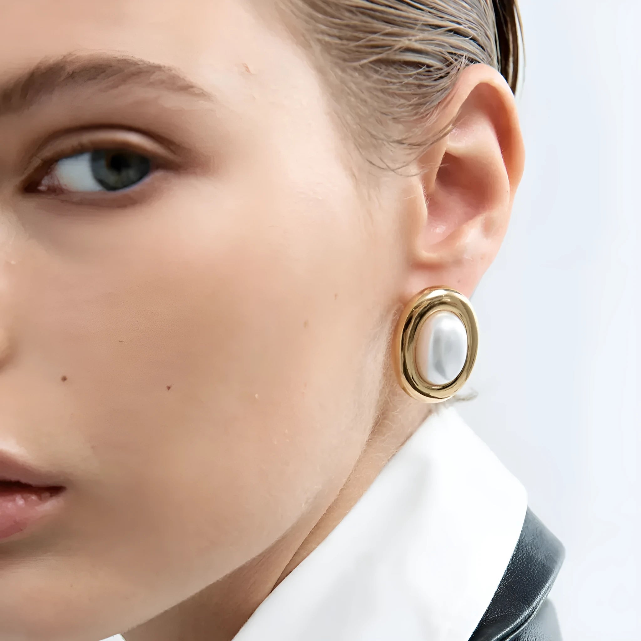 A pair of stainless steel stud earrings for women featuring a single vintage pearl, with butterfly clutch backings visible.