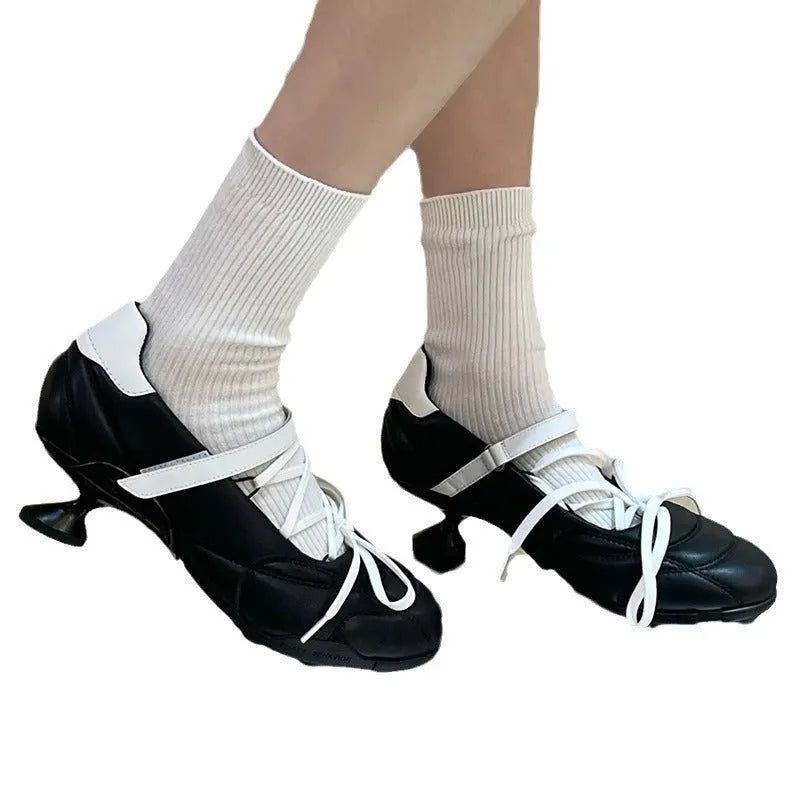 Women's silver lace-up sports shoes with a bow detail on the front, showing a low-top and round toe design.
