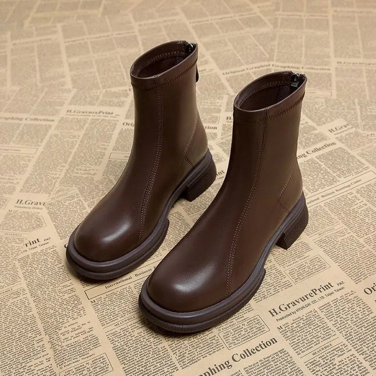 Women's black ankle boots with a flat heel, round toe, and a back zip fastening on a rubber sole.