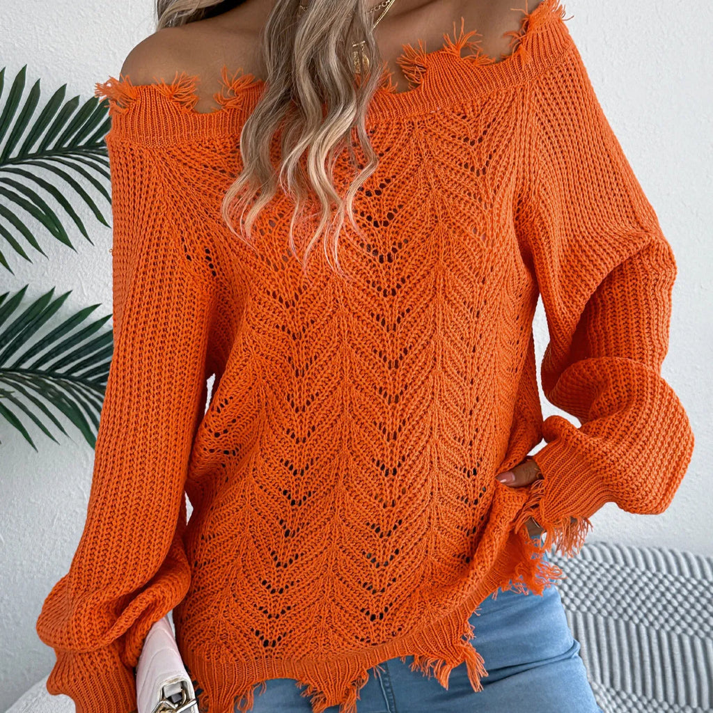 A woman wearing a white hollow-out cut off-the-shoulder pullover sweater in a street fashion style.