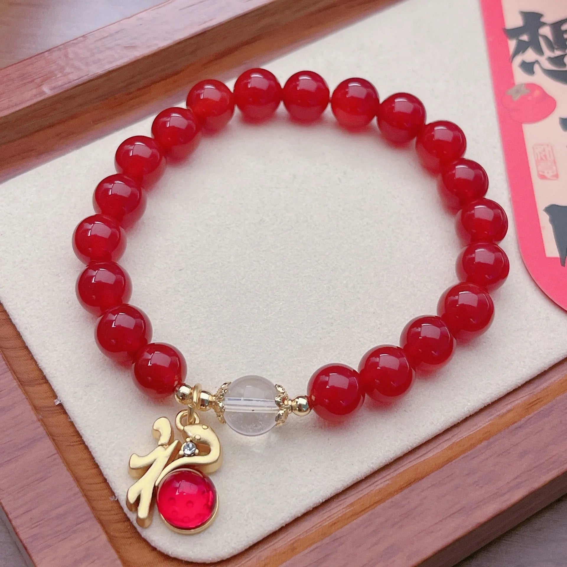 A red agate bracelet for women with Chinese style dragon and lucky bag motifs.