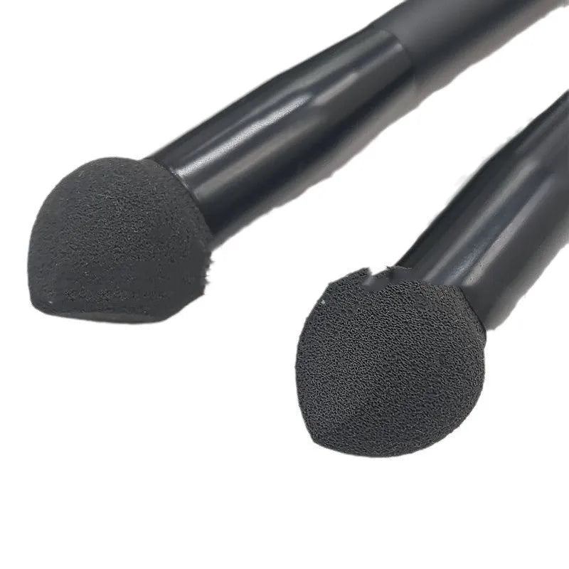 Black dual-ended concealer brush with a wooden handle and a pointed sponge applicator tip for under-eye makeup.