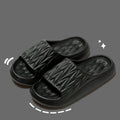 Pair of leaf-textured EVA indoor slippers on a solid background, showing non-slip sole.