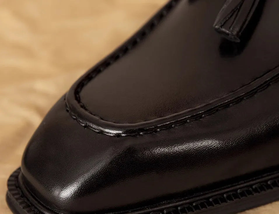 Men's brown leather loafers with fringed detail and slip-on design on rubber sole