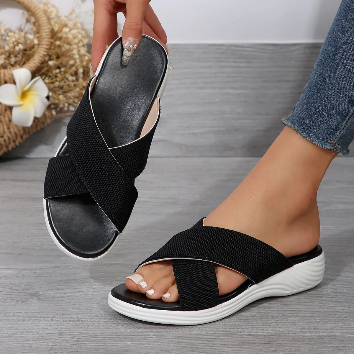 Black women's wedge heel peep-toe slippers with cross-strap design on a thick rubber sole