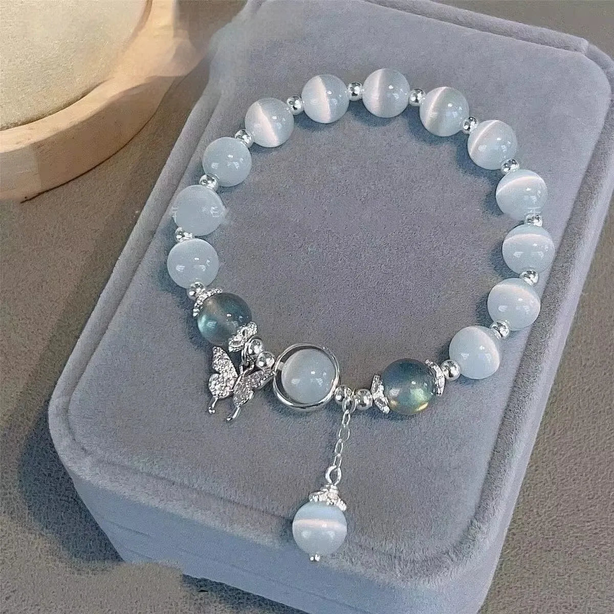 Handmade glass butterfly charm bracelet for women in a drop shape with round details.