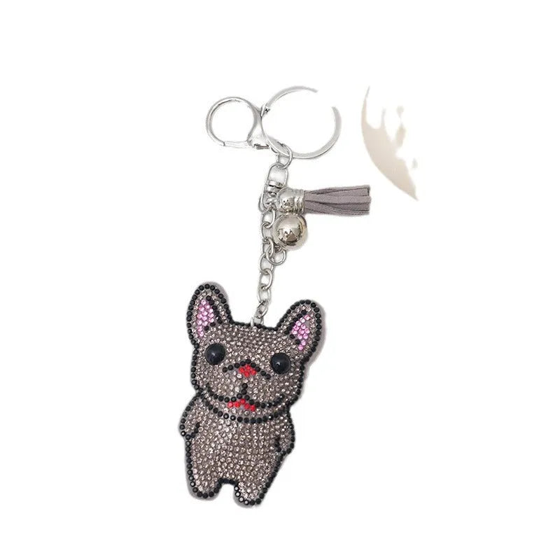 Close-up of a rhinestone dog charm keychain in a caramel colour with sparkling stones on a metal base.