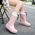 Women's solid colour PVC rain boots with non-slip sole in apricot, black, brown, or pink.