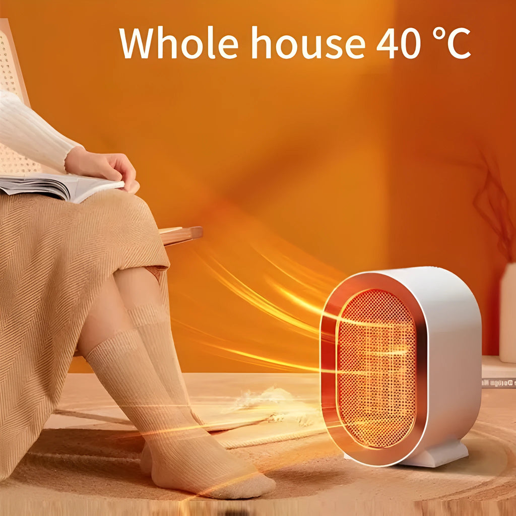 Compact black desktop electric ceramic fan heater with mechanical controls on a wooden desk