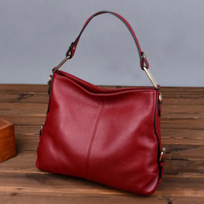 Square vertical genuine leather crossbody bag with multiple internal zipper compartments.
