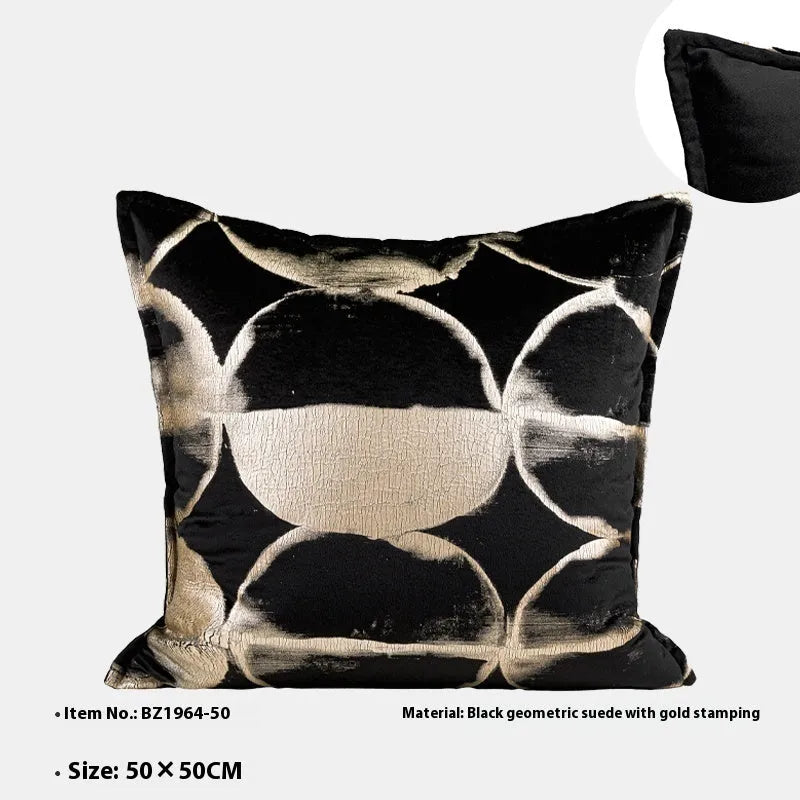 Black and gold abstract pattern flannel decorative cushion on a grey sofa.