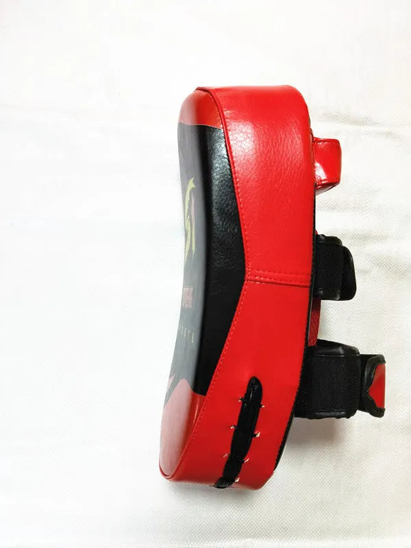 Black and red square hand-held martial arts kick pad with a double buckle strap on the back.