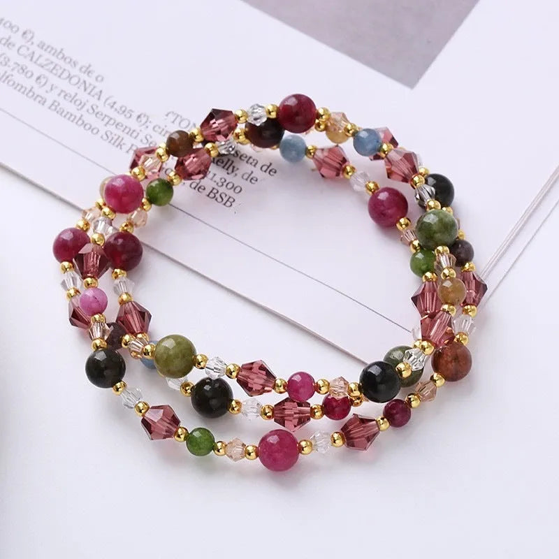 Women's adjustable three-ring crystal bracelet with tourmaline, strawberry quartz, and amethyst beads.