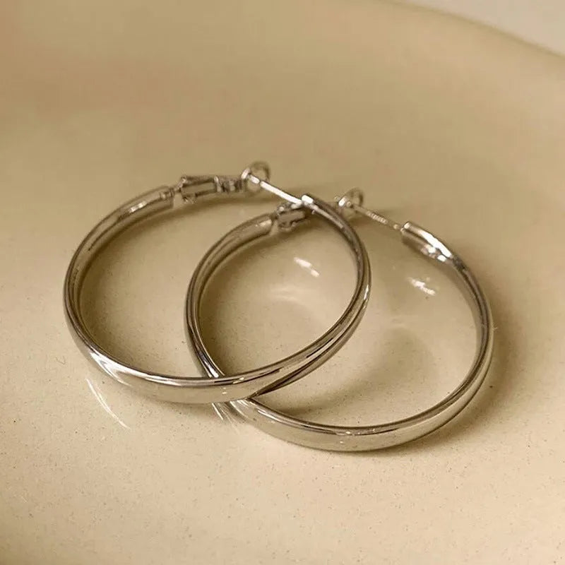 Circular metal earrings with 40mm diameter in gold and silver electroplated finishes
