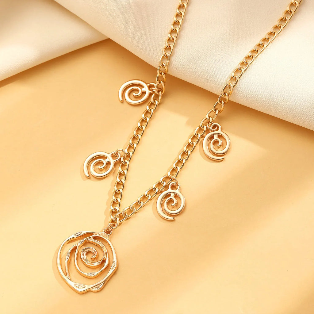 Spiral donut design necklace, bracelet, and ear hook set in gold or silver plating on a dark background.