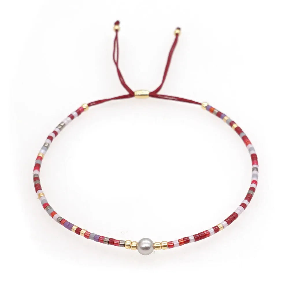 Handmade bohemian bracelet with colourful geometric glass beads on a female wrist.