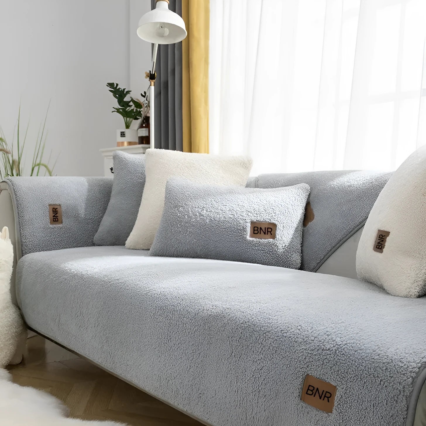 Lambswool sofa cover in solid colour on a sofa, shown in blue, grey, green, white, or yellow.
