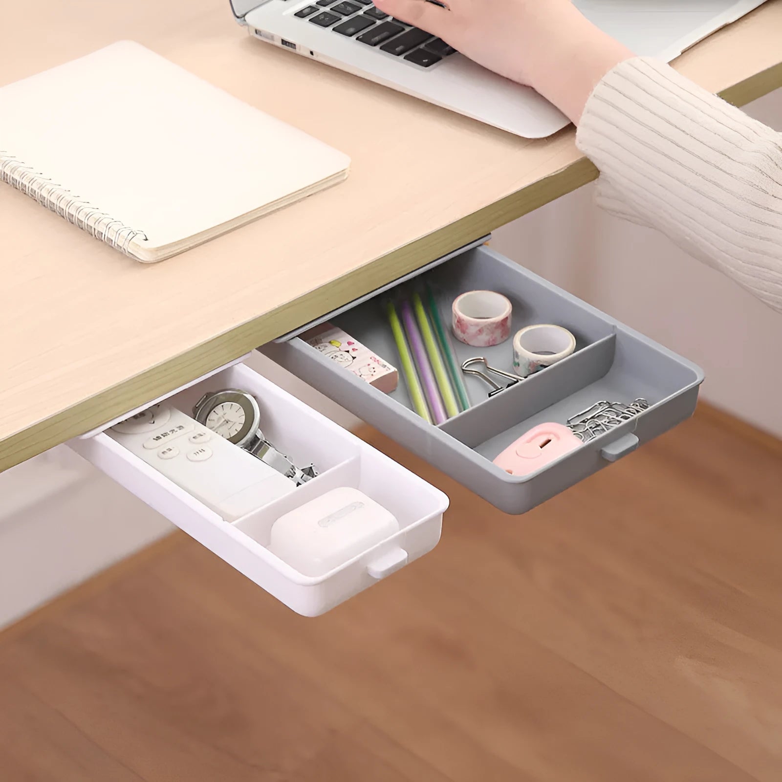 Adhesive under table storage drawer in plastic with covered grid design, shown in grey colour