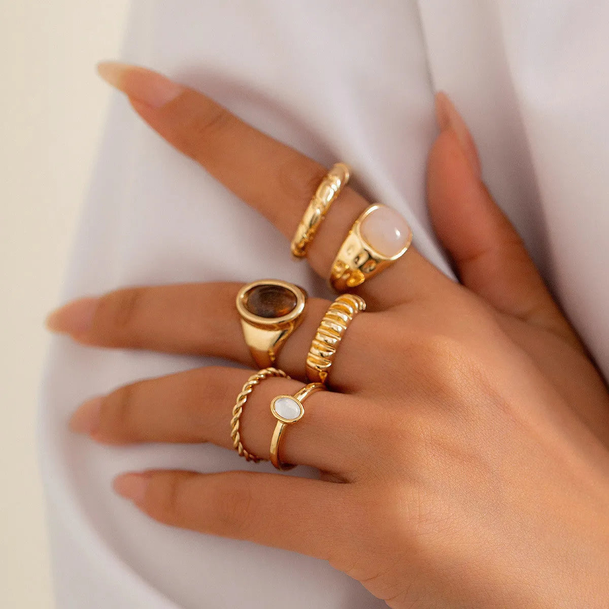 Six geometric alloy rings with irregular designs in light gold colour arranged together