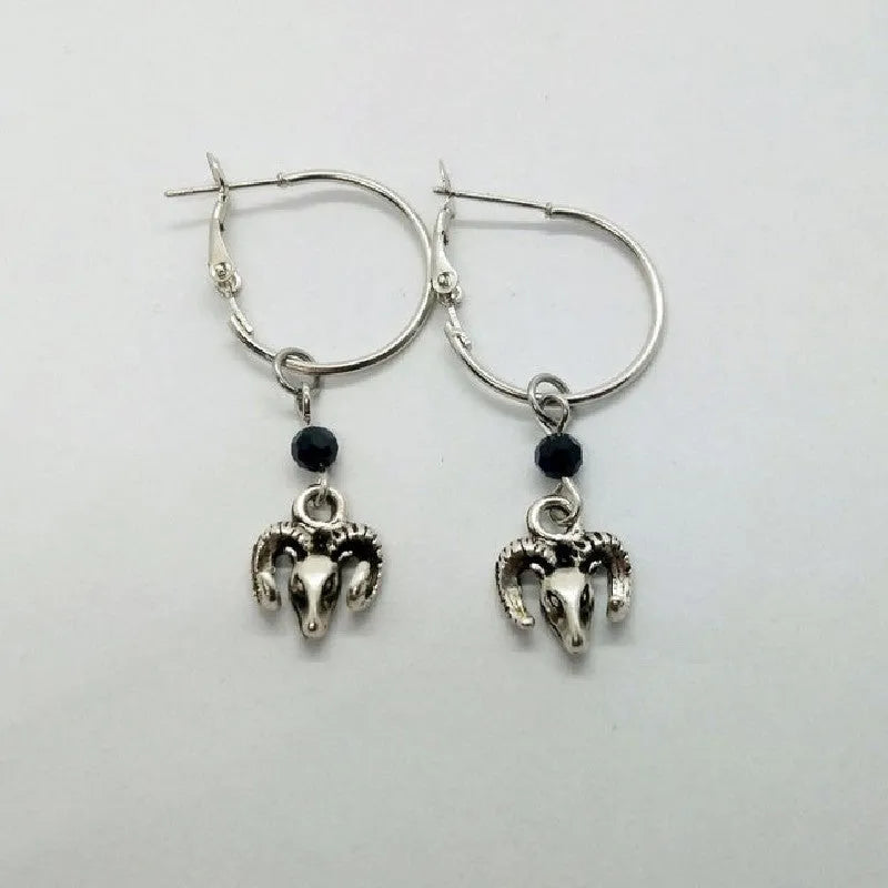 Silver coloured round alloy earrings featuring an engraved Tibetan antelope design.