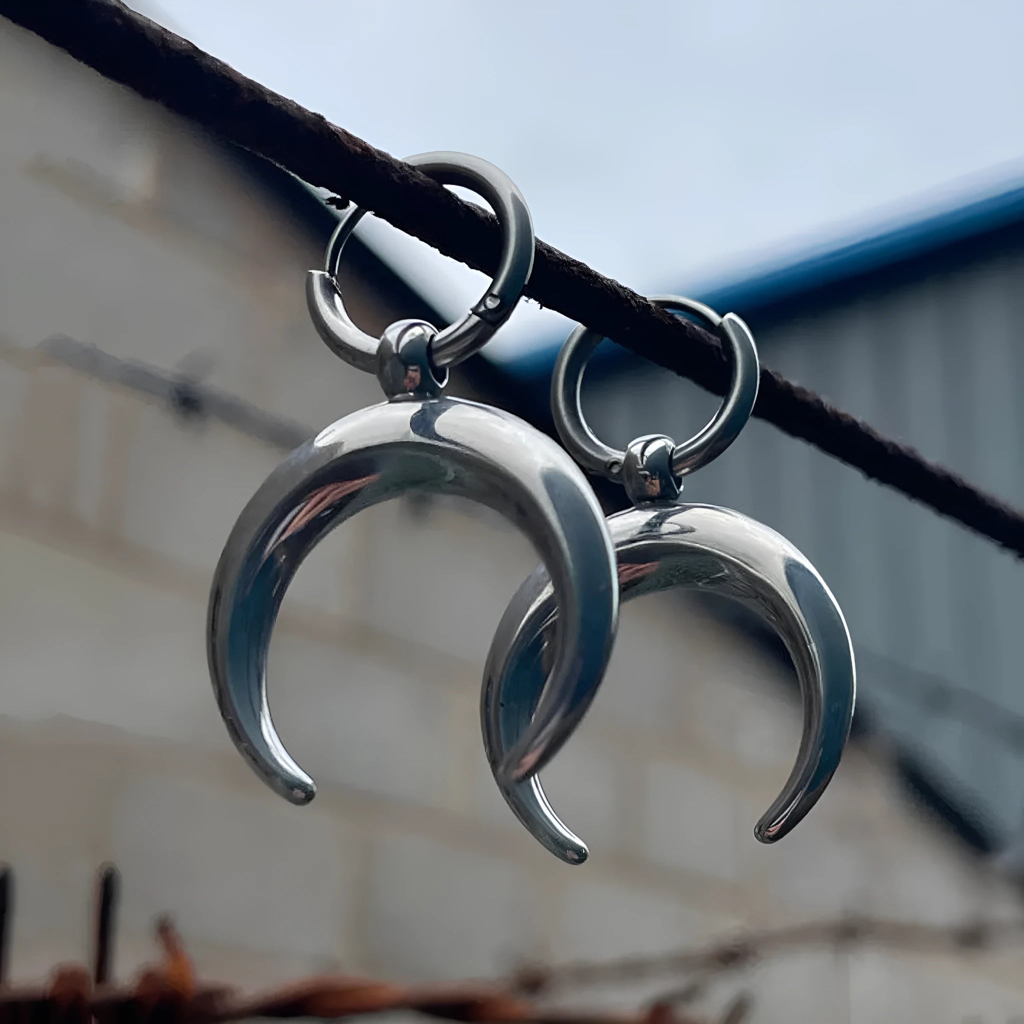 Silver alloy big hoop earrings with a gothic moon design and ear clip back.