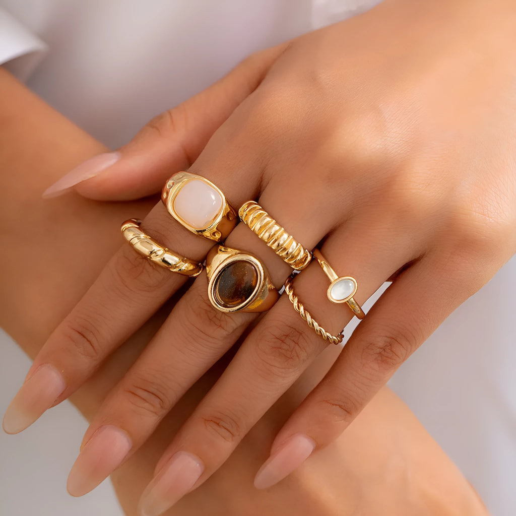 Six geometric alloy rings with irregular designs in light gold colour arranged together