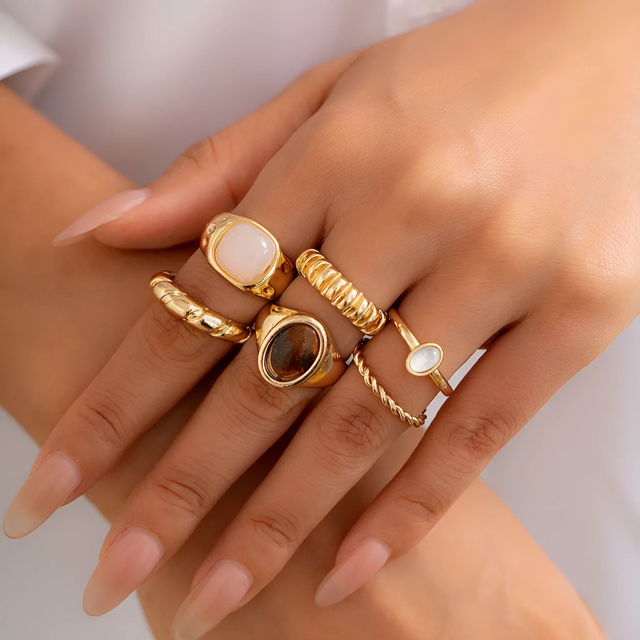 Six geometric alloy rings with irregular designs in light gold colour arranged together