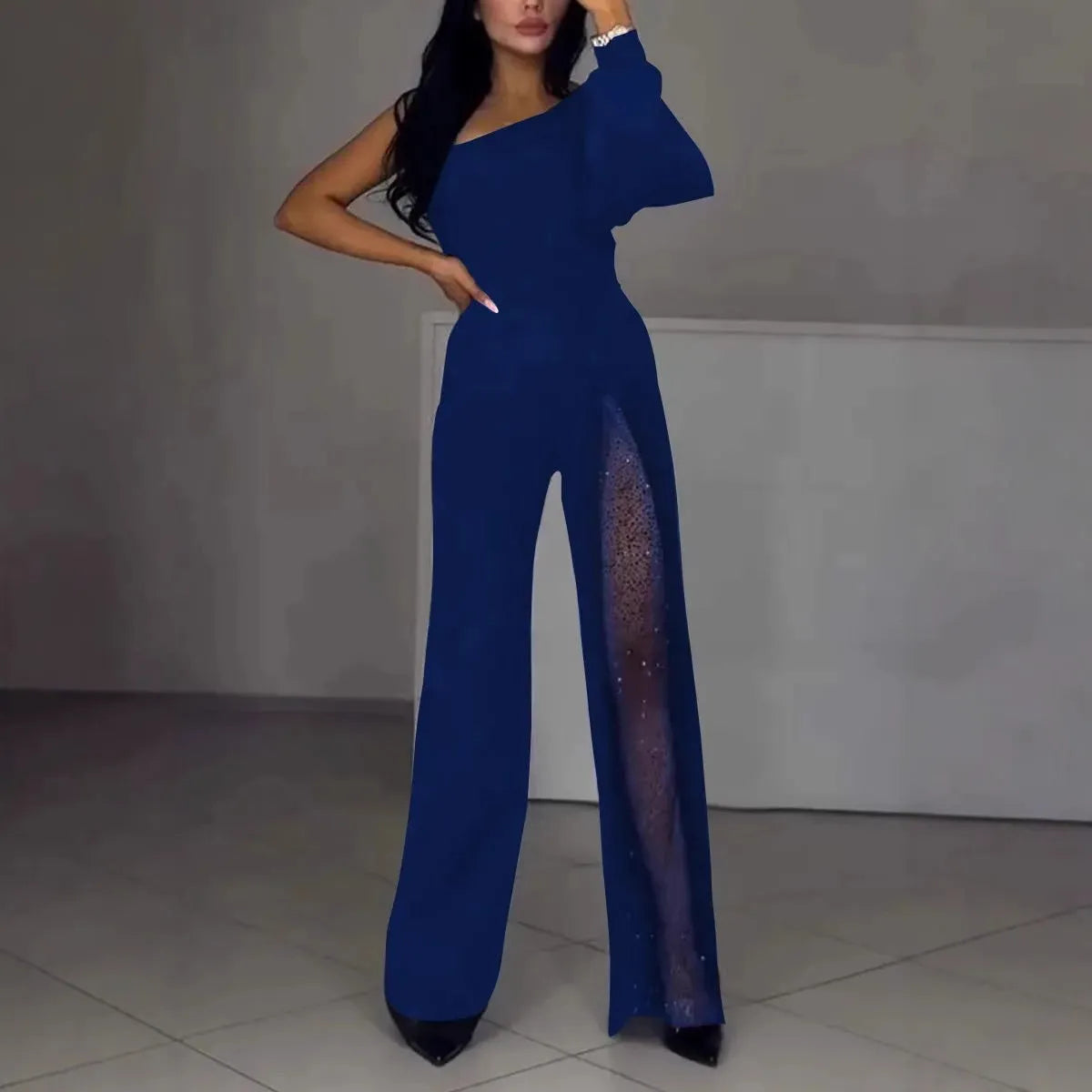 Women's black jumpsuit with an oblique asymmetric shoulder cut and a high slit on the leg.