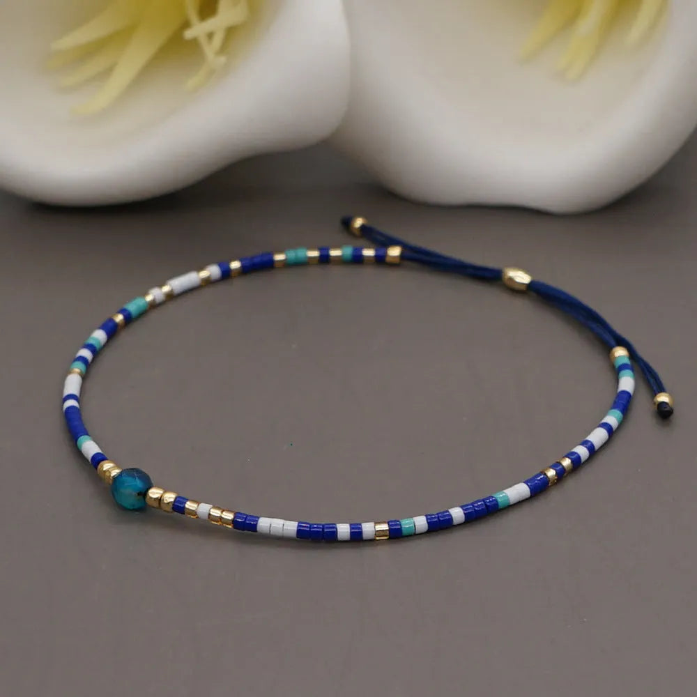 Handmade bohemian bracelet with colourful geometric glass beads on a female wrist.