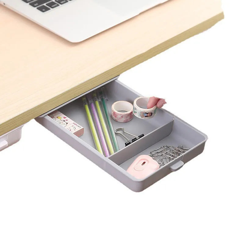 Adhesive under table storage drawer in plastic with covered grid design, shown in grey colour
