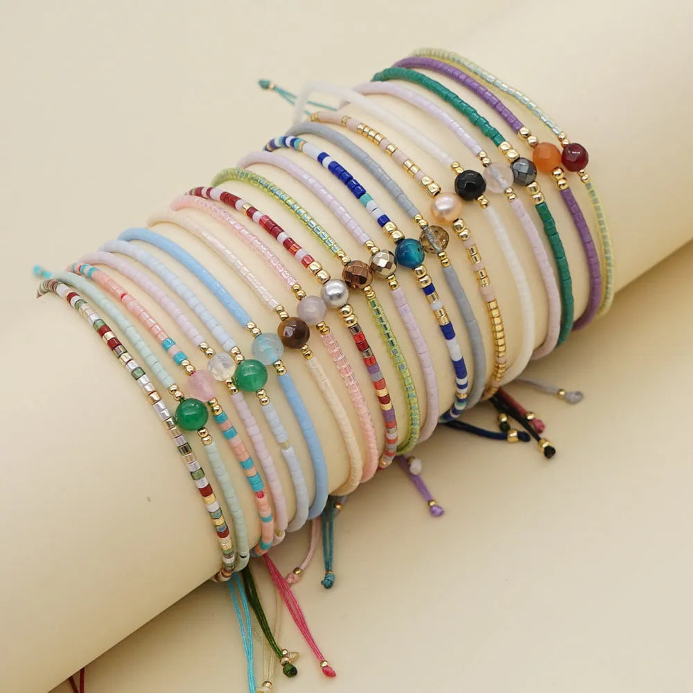 Handmade bohemian bracelet with colourful geometric glass beads on a female wrist.