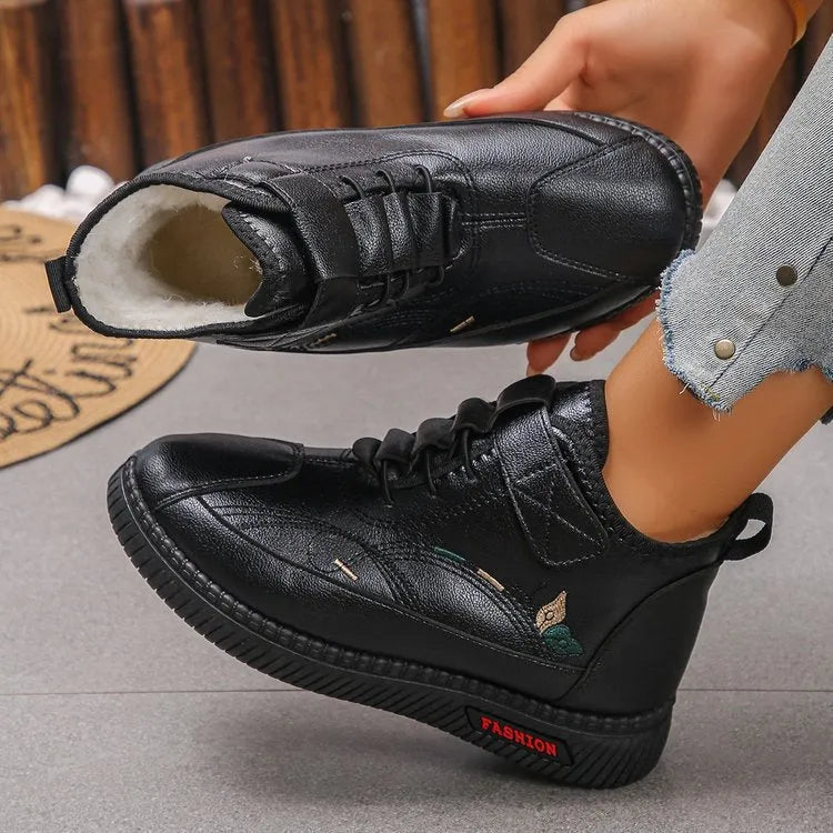 Women's black velvet house shoes with a hollow-out design and non-slip rubber sole.