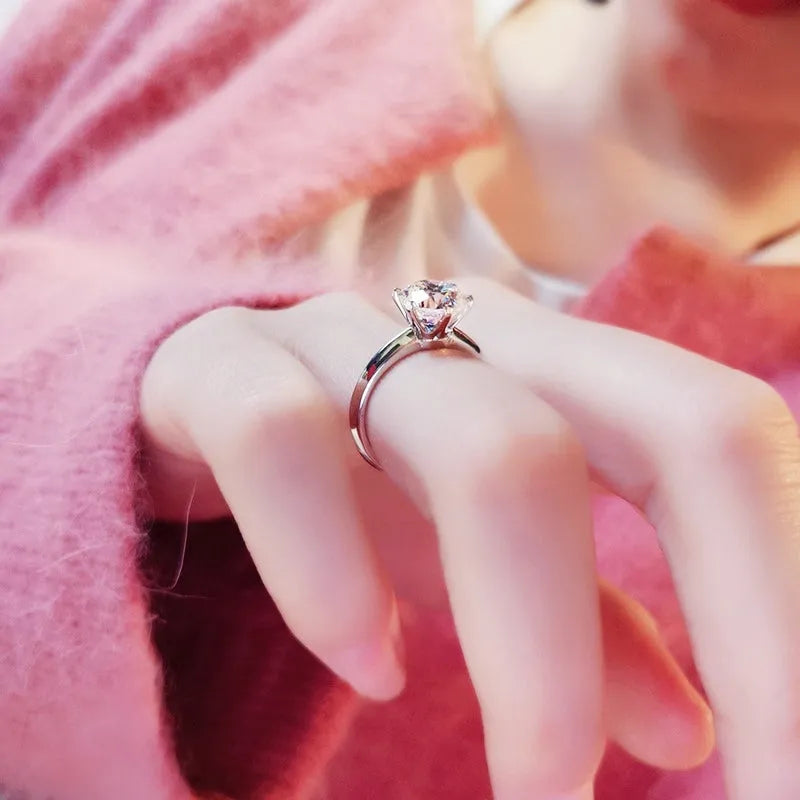 White gold plated geometric ring with a six-claw setting holding a central zircon stone.