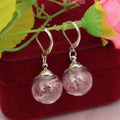 Transparent glass ball earrings on a French hook, showing dandelion seed design in silver and bronze finishes.