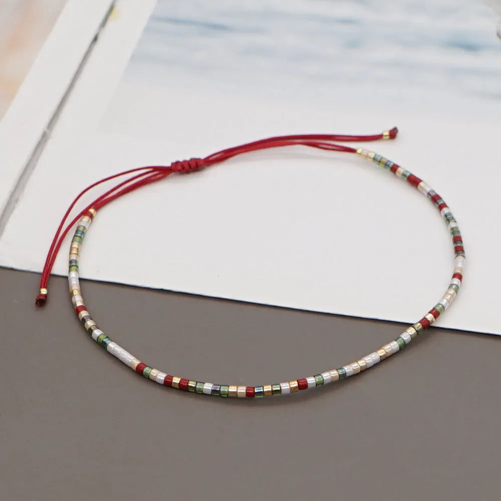 Handmade bohemian bracelet with colourful geometric glass beads on a female wrist.