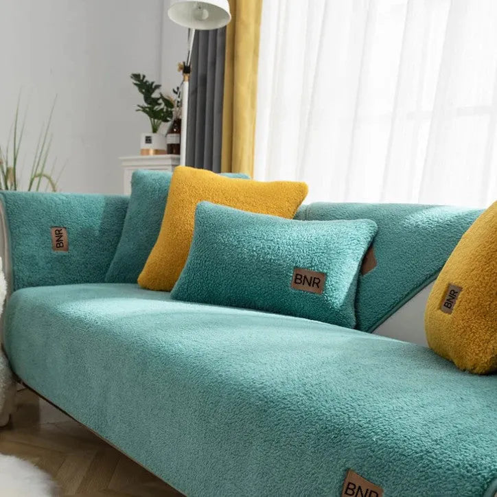 Lambswool sofa cover in solid colour on a sofa, shown in blue, grey, green, white, or yellow.