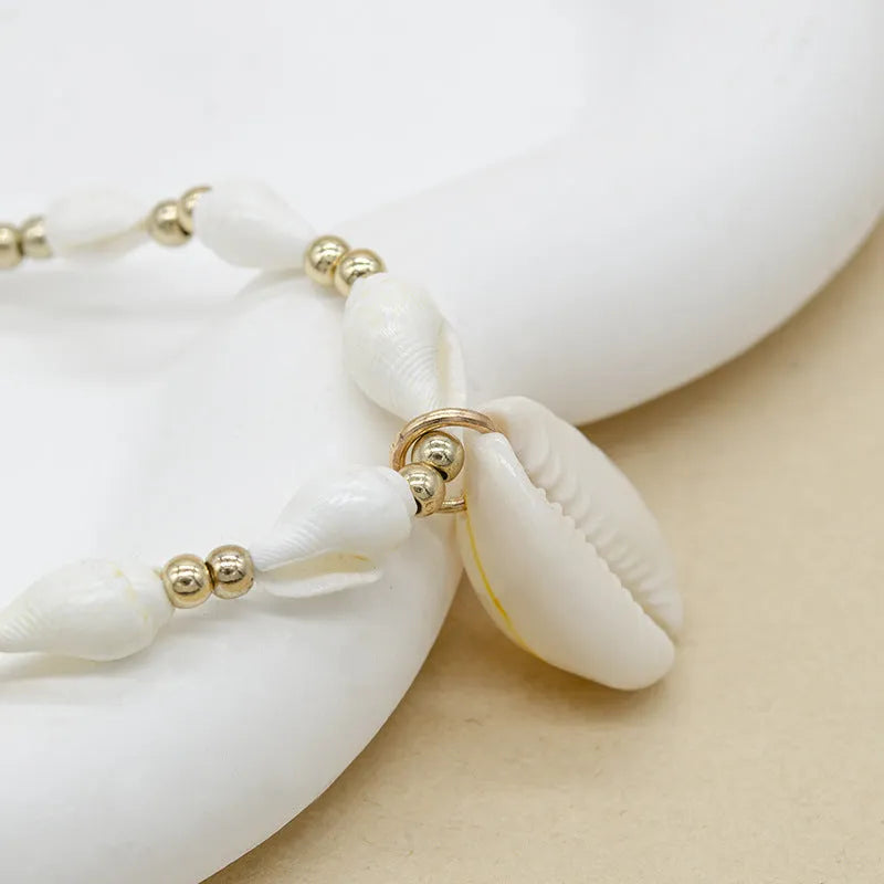 White conch shell pendant and bead necklace on a regular chain.
