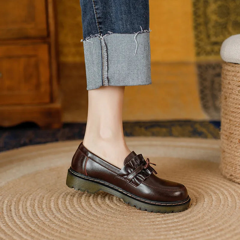 Women's black leather shoes with round toe, chunky flat heel, and low-top design on a white background.