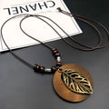 Wooden pendant necklace with alloy leaf details on a brown adjustable wax line chain.