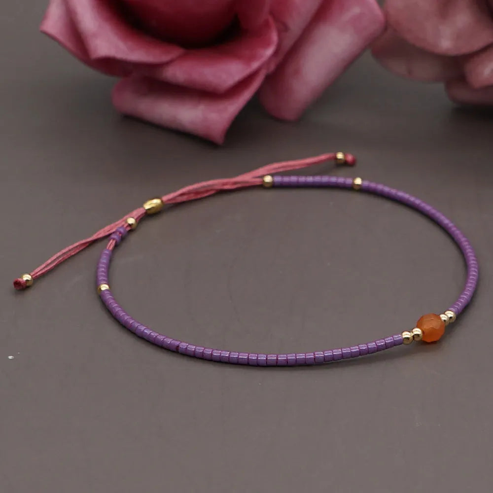 Handmade bohemian bracelet with colourful geometric glass beads on a female wrist.