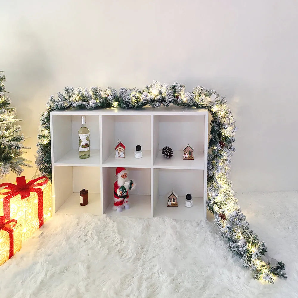 Snow-flocked Christmas rattan garland vine in red, draped on a mantelpiece.