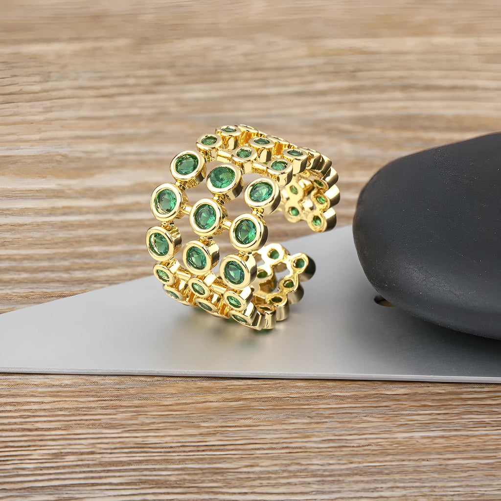 Wide gold-coloured ring with large green zircon stone on copper base with gold plating