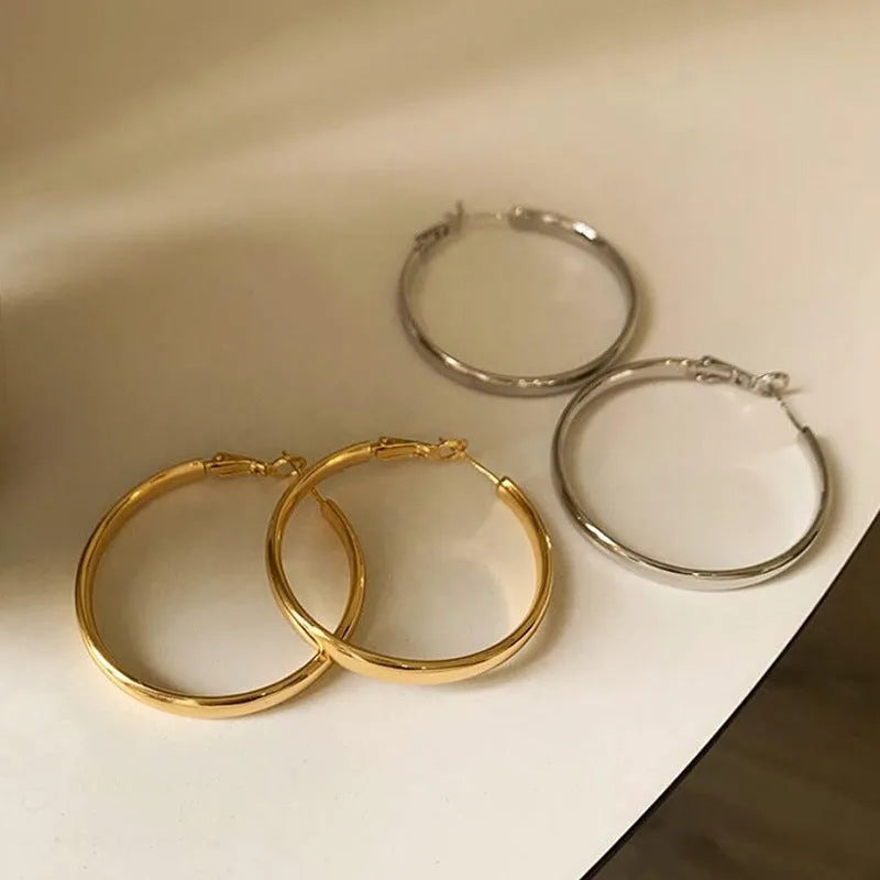 Circular metal earrings with 40mm diameter in gold and silver electroplated finishes