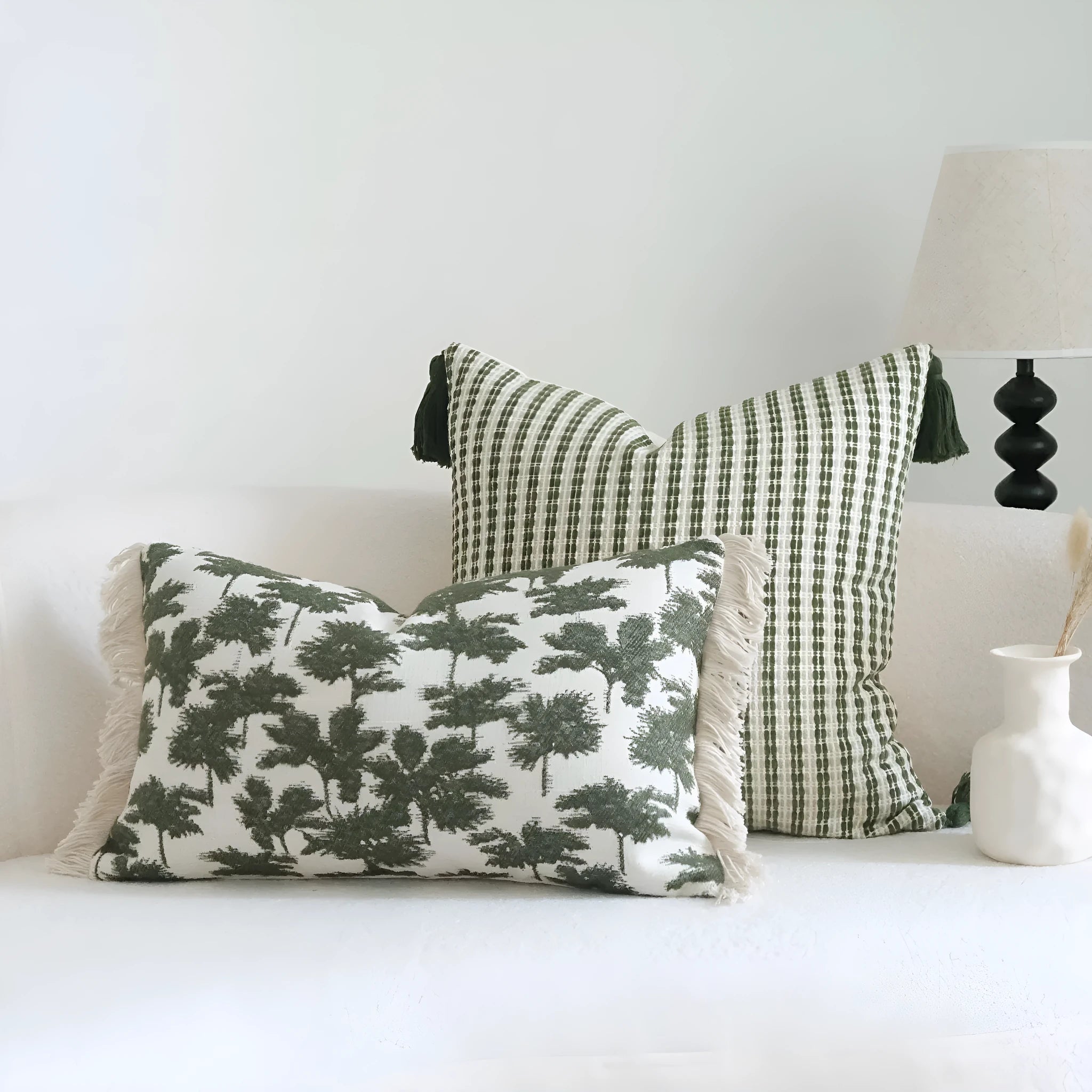 Green cotton and linen hotel sample pillow with tassel details and botanical patterns for display use