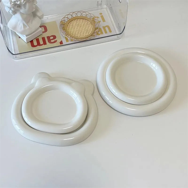 White porcelain plate with chubby toot or bear doodle pattern, shown in 15cm and 20cm round sizes.